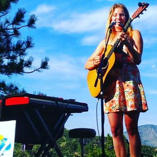 Shanna in a Dress performing live outdoors with acoustic guitar
